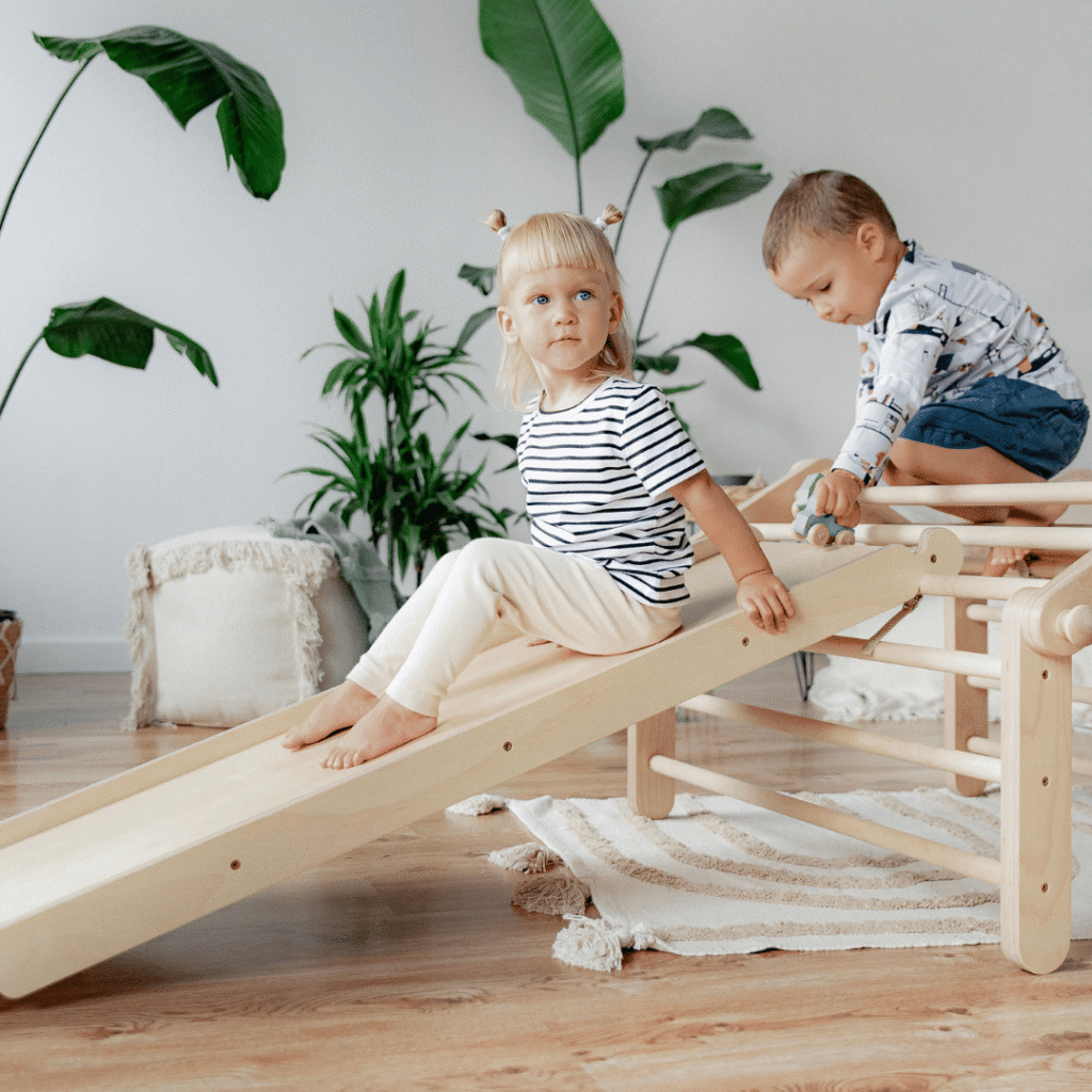 Kinderen spelen met de MOPITRI klimdriehoek met glijbaan